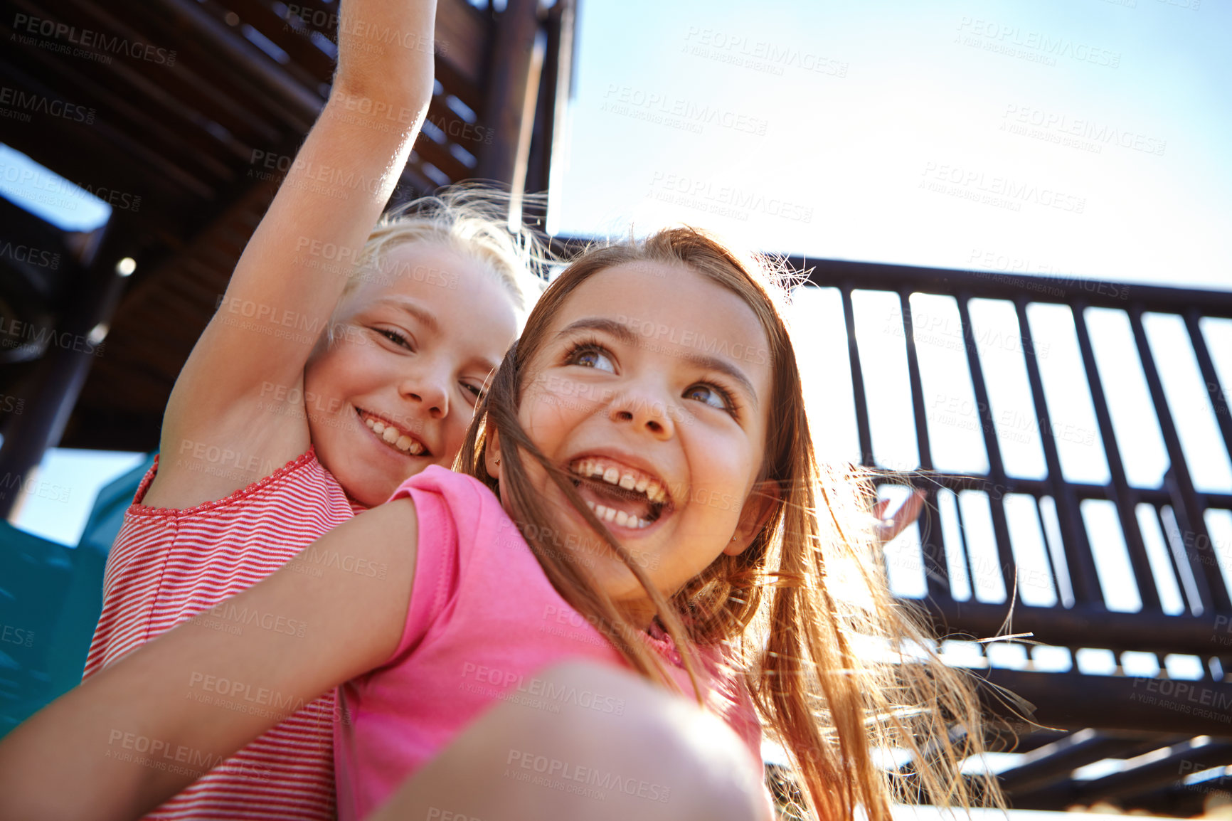 Buy stock photo Shot of two little girls on a slide at the play park