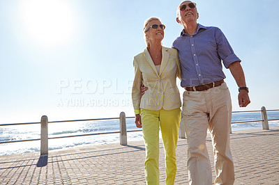Buy stock photo Shot of a senior couple taking a walk by the ocean