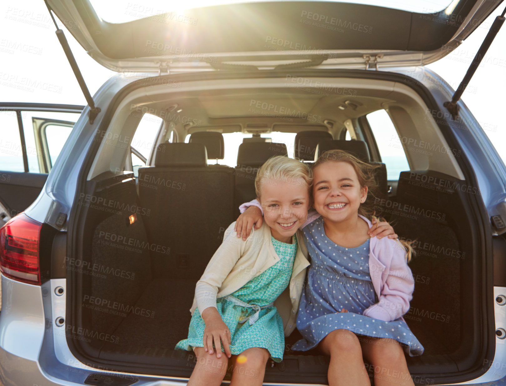 Buy stock photo Shot of two little girls sitting in the trunk of a car