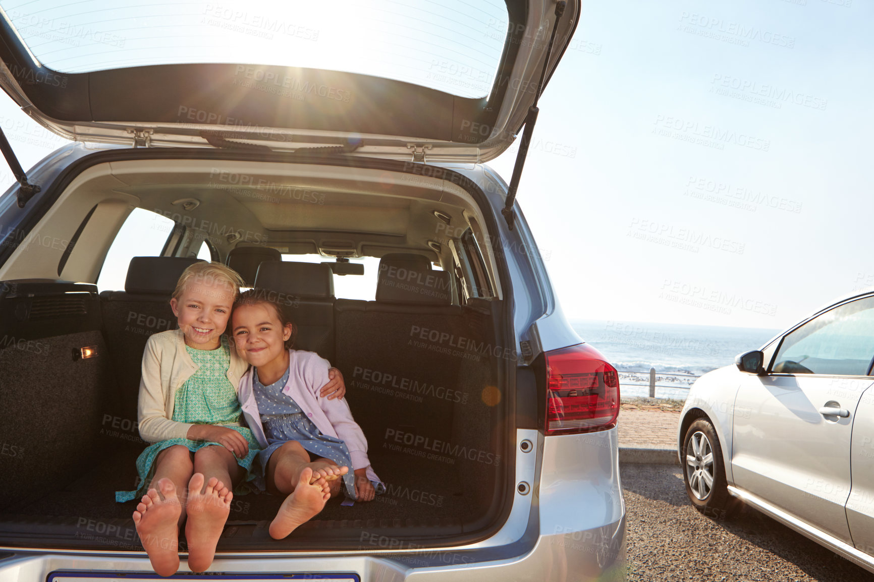 Buy stock photo Shot of two little girls sitting in the trunk of a car