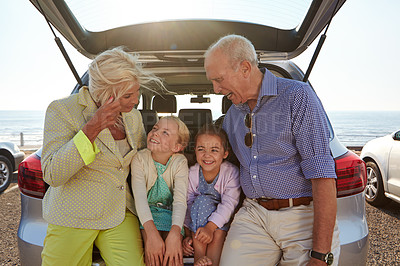 Buy stock photo Shot of two little girls sitting in the trunk of a car with their grandparents