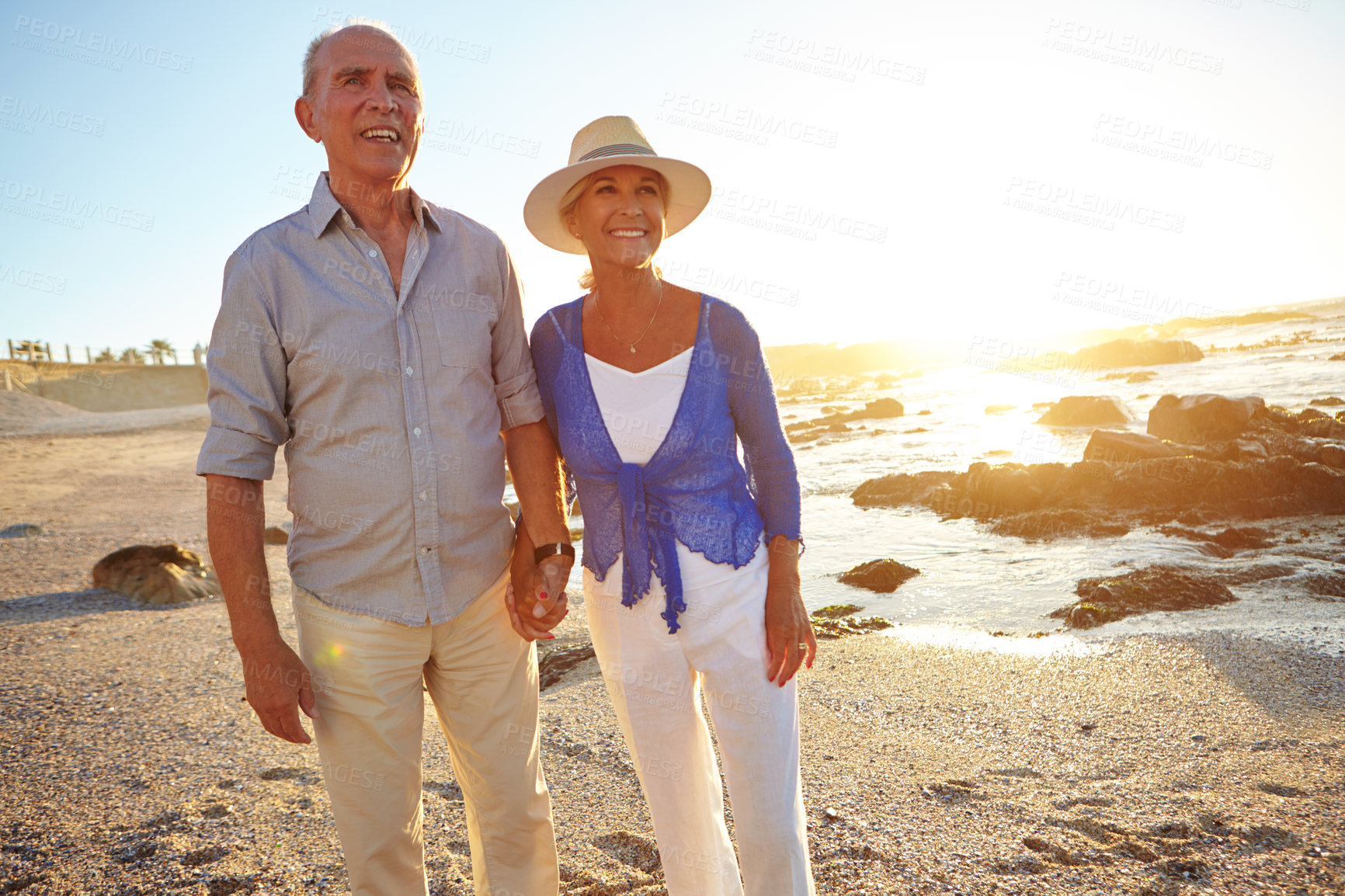 Buy stock photo Shot of an affectionate senior couple walking on the beach