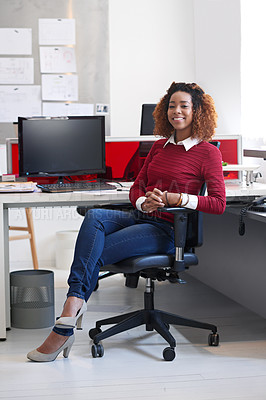 Buy stock photo Portrait of a young woman sitting at her workstation in an office