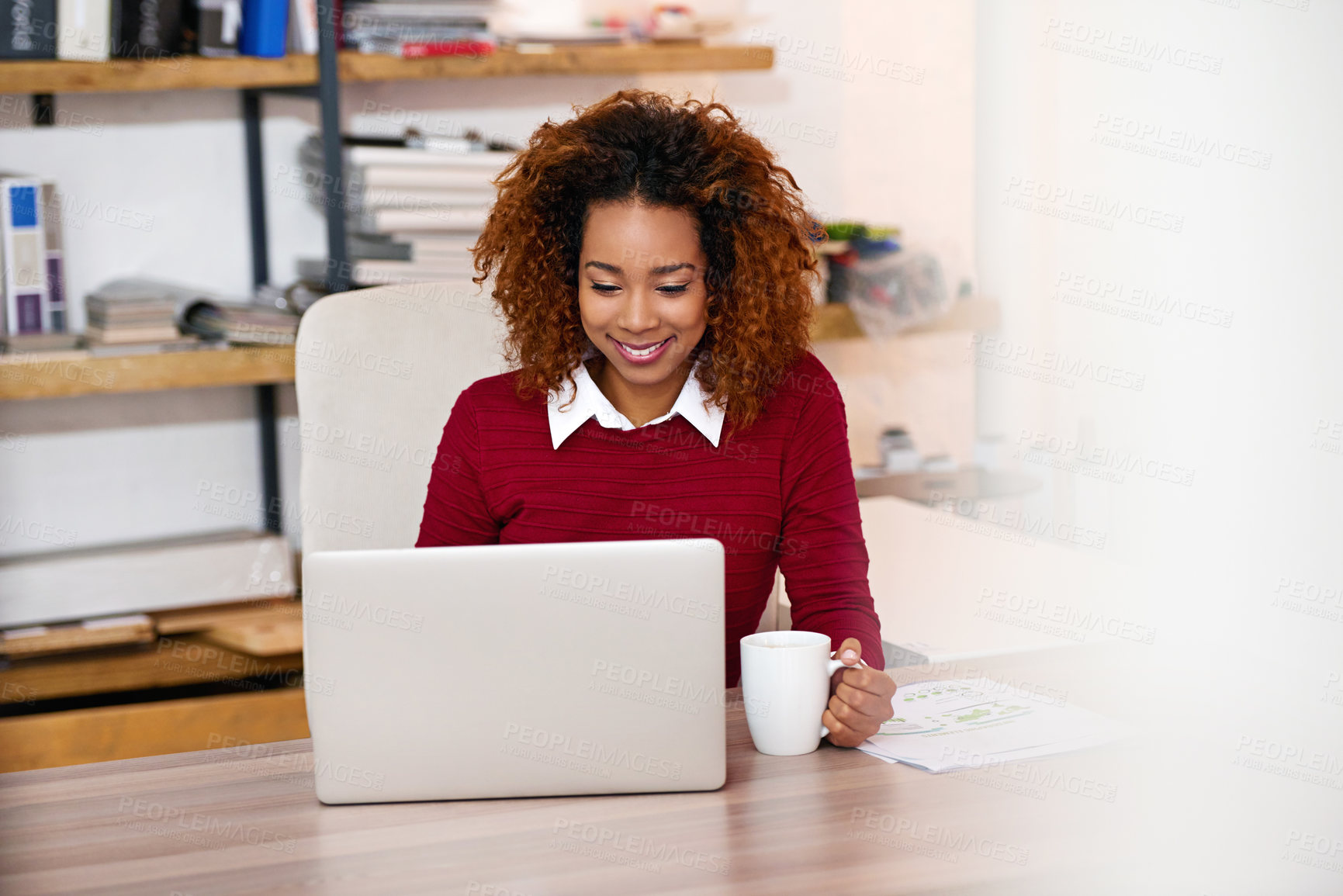 Buy stock photo Shot of a young woman working on a laptop in an office