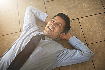 Buy stock photo High angle shot of a businessman lying on his office floor