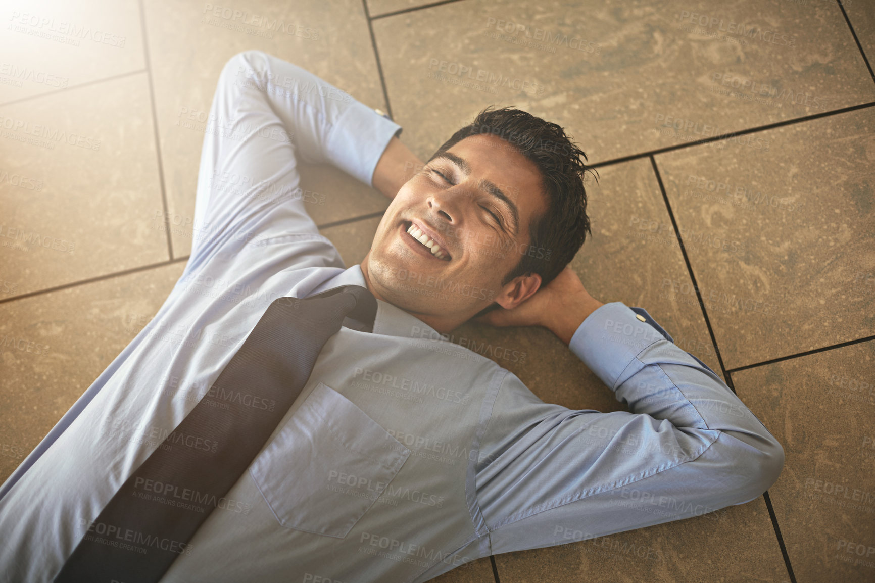 Buy stock photo High angle shot of a businessman lying on his office floor