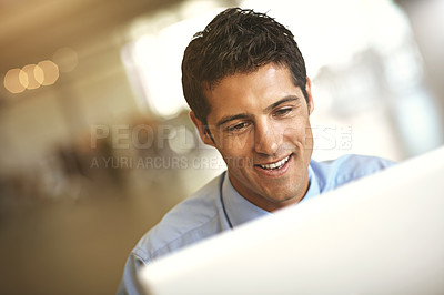 Buy stock photo Computer, face and blurred background with a business man at work on a project in his office. Smile, internet and technology with a young male employee working on a desktop for a company report