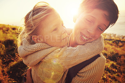 Buy stock photo Shot of an adorable little girl embracing her older brother