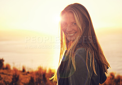 Buy stock photo Sunset, happy and portrait of woman by ocean for adventure, relaxing and enjoy weekend outdoors. Nature, smile and person with flare on hill for holiday, vacation and travel destination in evening