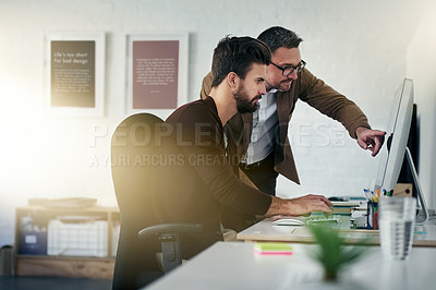 Buy stock photo Shot of two designers discussing something on a computer screen