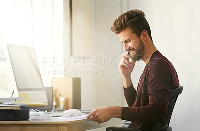 Buy stock photo Shot of a businessman talking on his cellphone while looking at paperwork in his office