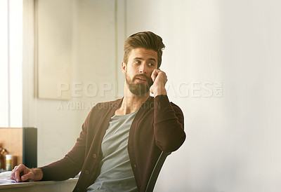 Buy stock photo Cropped shot of a businessman talking on his cellphone while sitting in his office