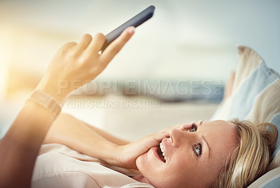 Buy stock photo Shot of a mature woman looking surprised while reading a text message at home