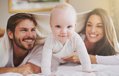 Buy stock photo Baby, mother and father playing with blanket in bedroom for love, care and quality time together. Portrait of cute newborn child with parents, happy family and relax with bedding over heads at home