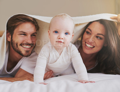 Buy stock photo Mother, father and baby under blanket on bed for love, care and quality time together. Portrait of playful child, happy family and kids relaxing in bedroom with bedding fort, fun and bonding in house