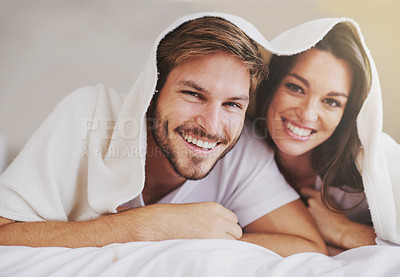 Buy stock photo Smile, love and portrait of couple with blanket for relaxing, bonding and resting on bed together. Happy, romantic and young man and woman laying with duvet in bedroom at hotel, home or apartment.