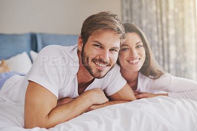 Buy stock photo Happy, hotel and portrait of couple on bed for relaxing, bonding and resting together on vacation. Smile, romantic and young man and woman laying in bedroom at modern apartment or home on weekend.