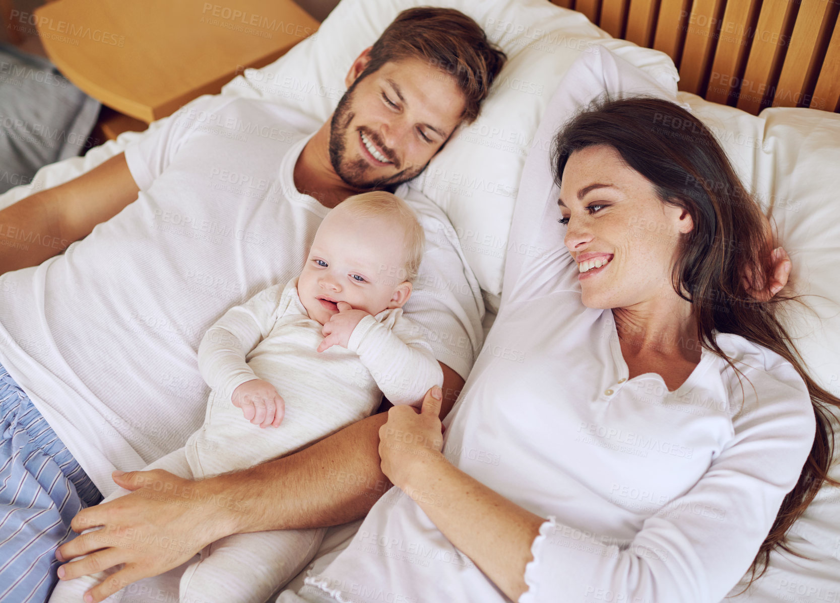 Buy stock photo Top view of mother, father and baby on bed for love, care and quality time together. Happy parents, family and newborn kid relaxing in bedroom with support, childhood development and bonding at home