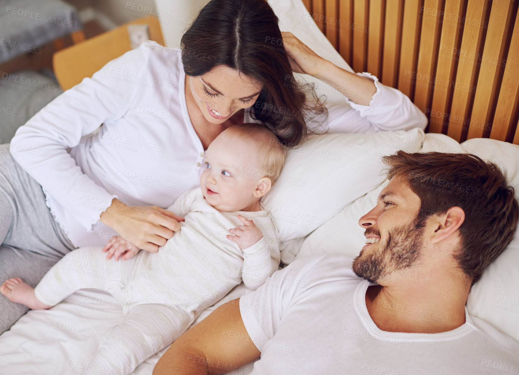 Buy stock photo Top view of mom, dad and baby on bed for love, care and quality time together at home. Happy parents, family and newborn kid relax in bedroom with support, childhood development and smile for bonding