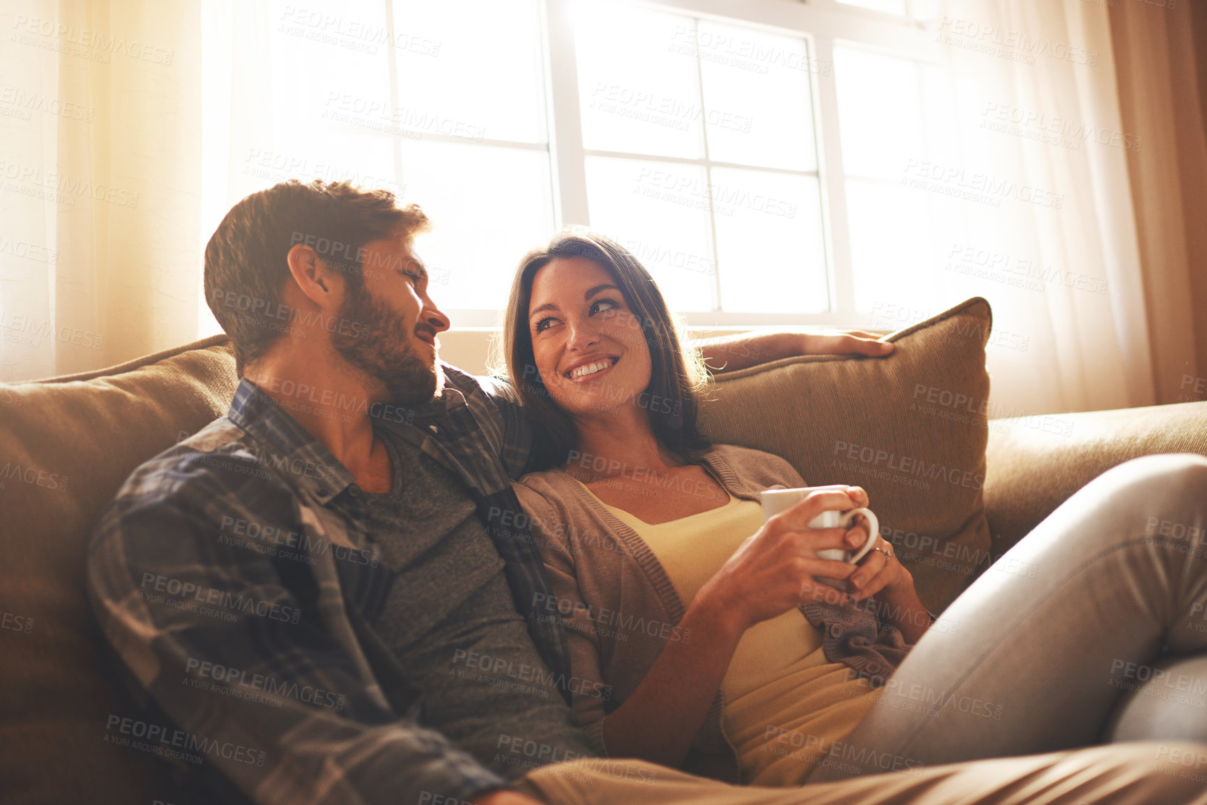 Buy stock photo Cropped shot of a young couple relaxing on the sofa at home