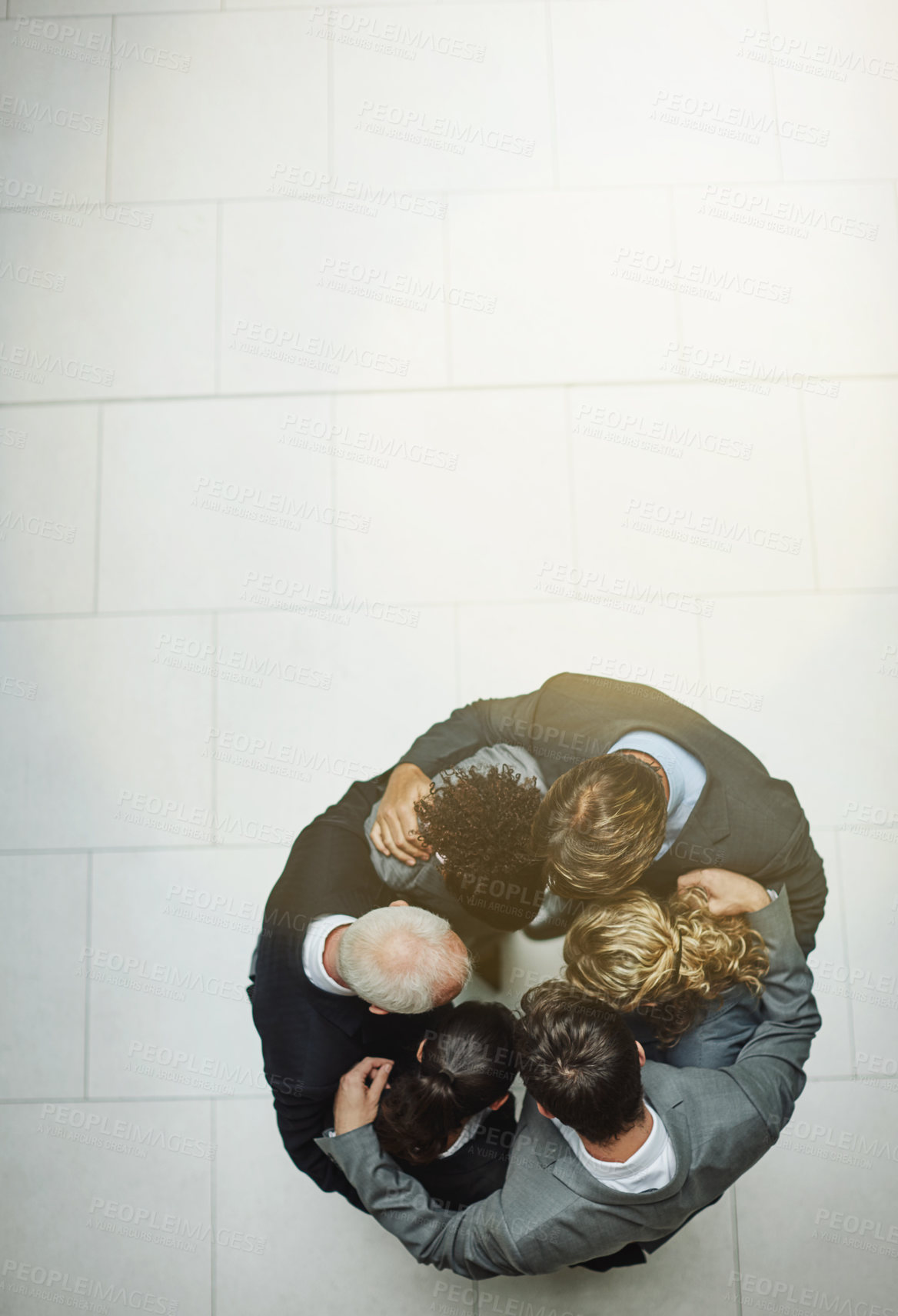 Buy stock photo High angle shot of a group of businesspeople standing in a huddle