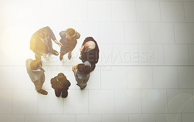 Buy stock photo High angle shot of a group of businesspeople talking in the office lobby