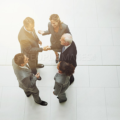 Buy stock photo Top view, handshake and group of business people in meeting for deal, agreement or crm on mockup. Above, shaking hands and employees with b2b collaboration, partnership and welcome to company office.