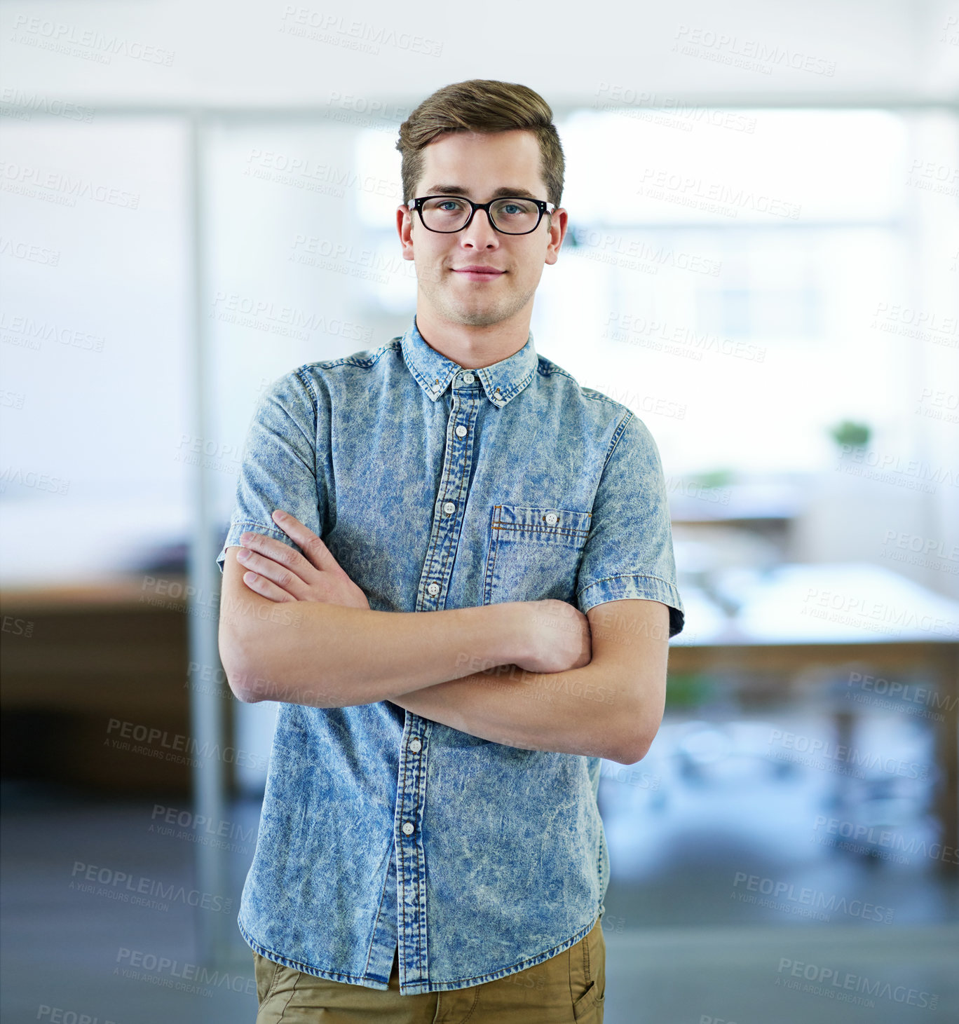 Buy stock photo Cropped portrait of a handsome businessman standing in the office with his arms folded