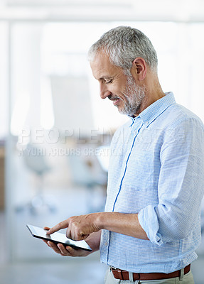 Buy stock photo Cropped shot of a mature businessman using his tablet