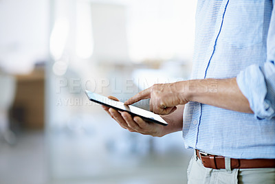 Buy stock photo Cropped shot of an unrecognizable businessman using his tablet