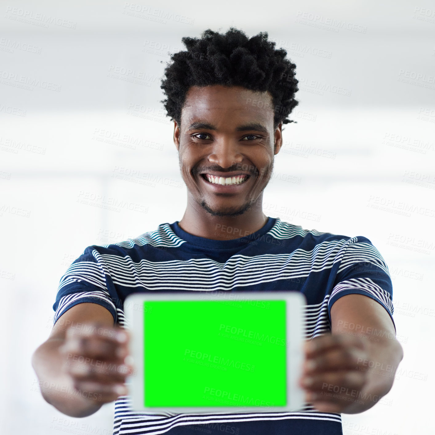 Buy stock photo Cropped portrait of a young businessman showing you a tablet while standing in the office corridor