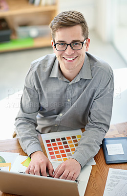 Buy stock photo Portrait of a male designer working on his laptop at his desk