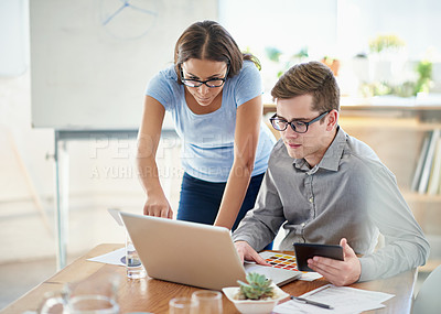 Buy stock photo Shot of two designers working together on a laptop in an office