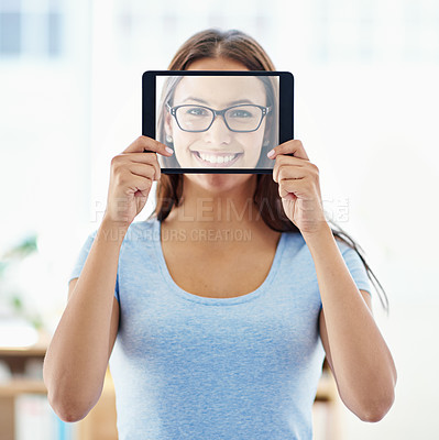 Buy stock photo A young woman holding a digital tablet with a transparent screen in front of her face