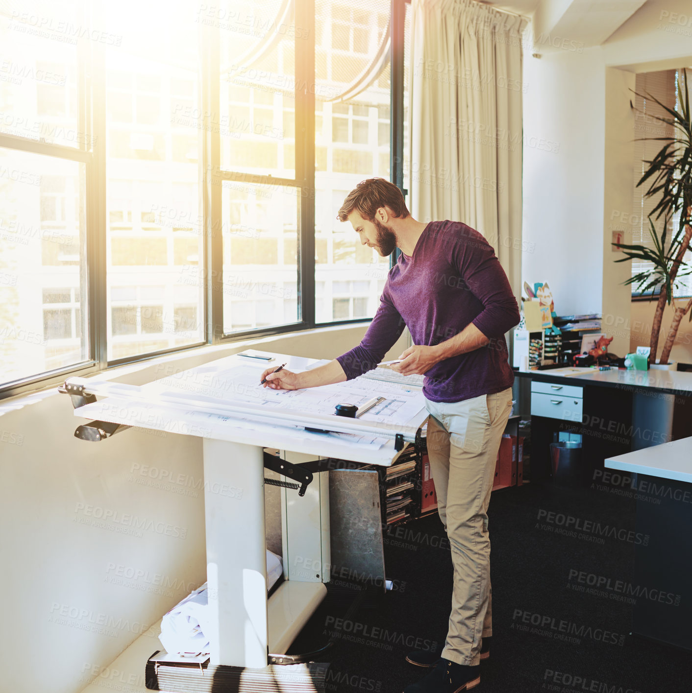 Buy stock photo Full length shot of a young architect working on his drafting table