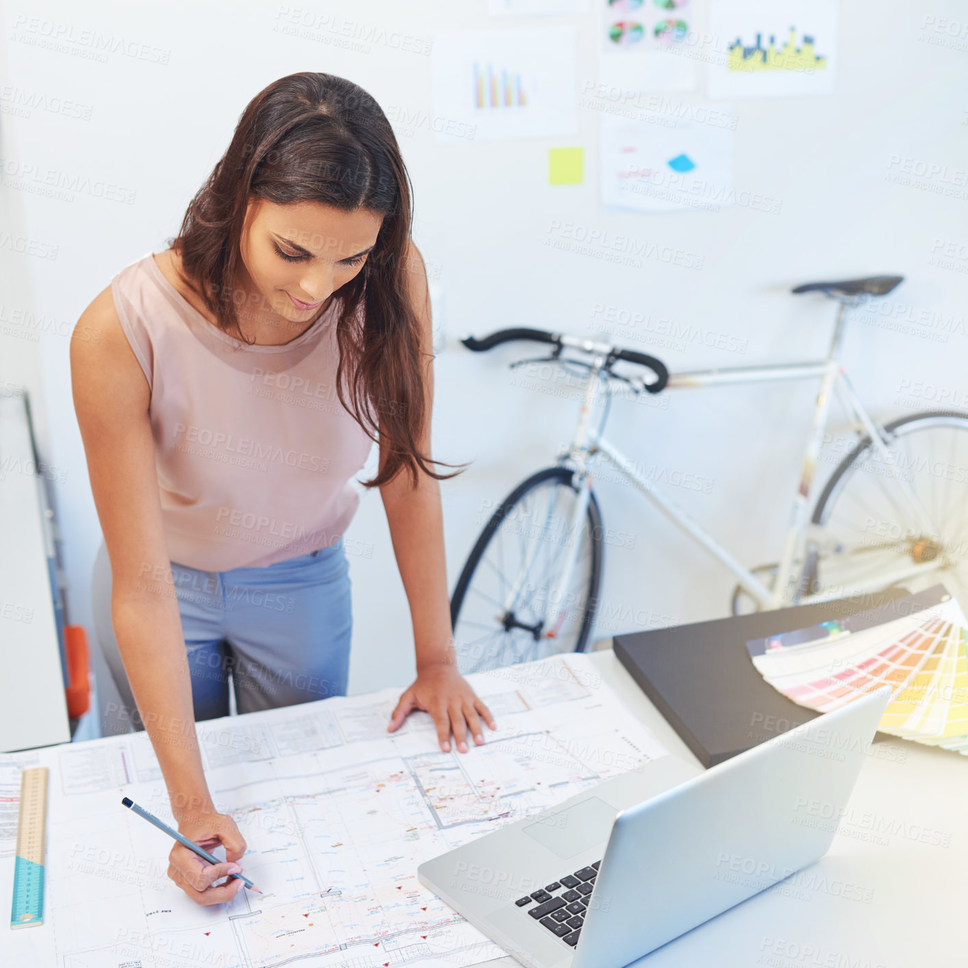 Buy stock photo Cropped shot of a young architect looking over some building plans