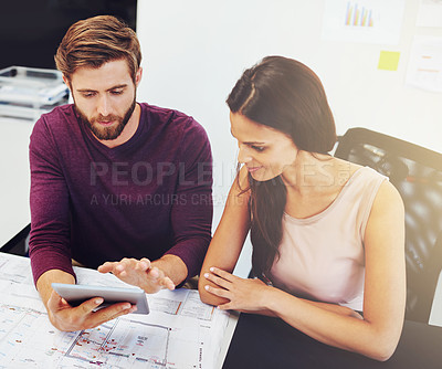 Buy stock photo Cropped shot of two young architects looking at a digital tablet