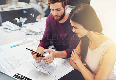 Buy stock photo Cropped shot of two young architects looking at a digital tablet