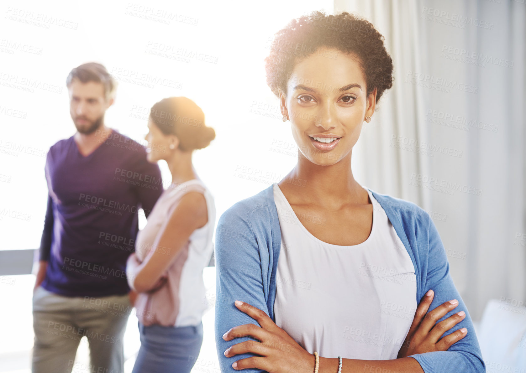 Buy stock photo Portrait of a young businesswoman with her colleagues standing in the background