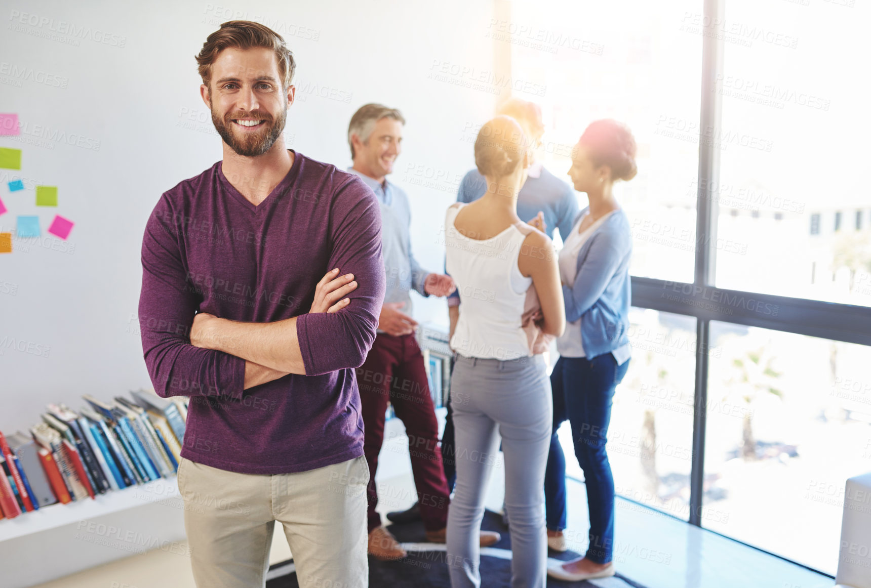 Buy stock photo Portrait of a young businessman with his colleagues standing in the background