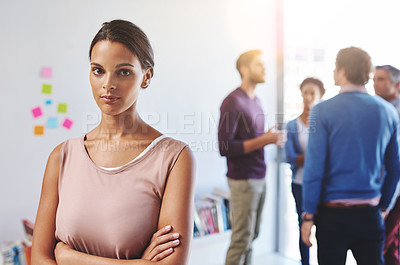 Buy stock photo Portrait of a young businesswoman with her colleagues standing in the background