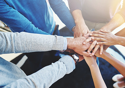 Buy stock photo Cropped shot of a group of businesspeople standing in a huddle with their hands stacked