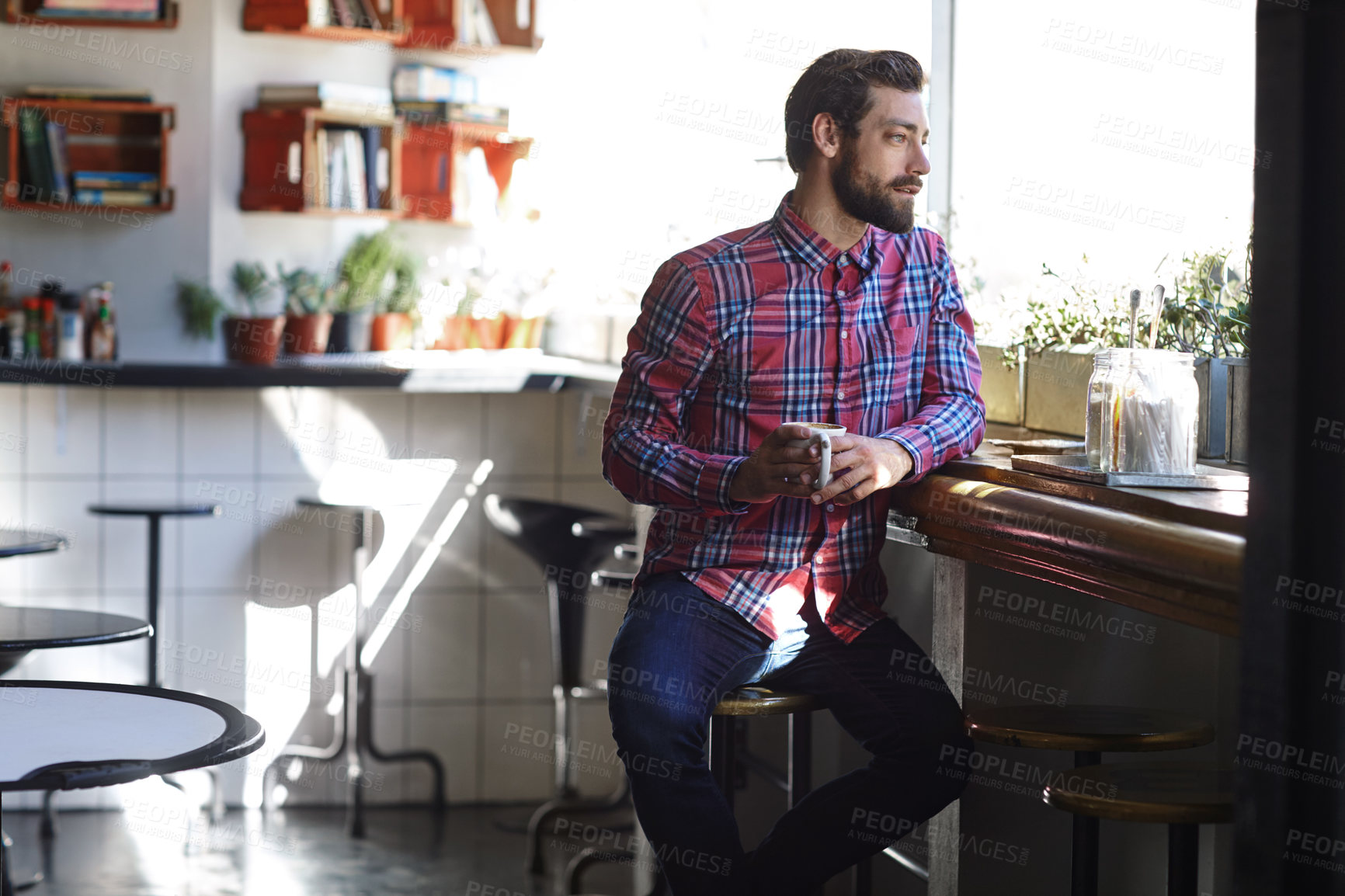 Buy stock photo Shot of a young man drinking coffee in a cafe