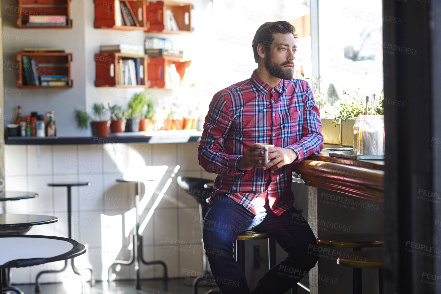 Buy stock photo Shot of a young man drinking coffee in a cafe