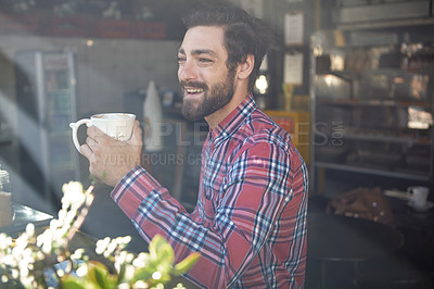 Buy stock photo Shot of a young man drinking coffee in a cafe