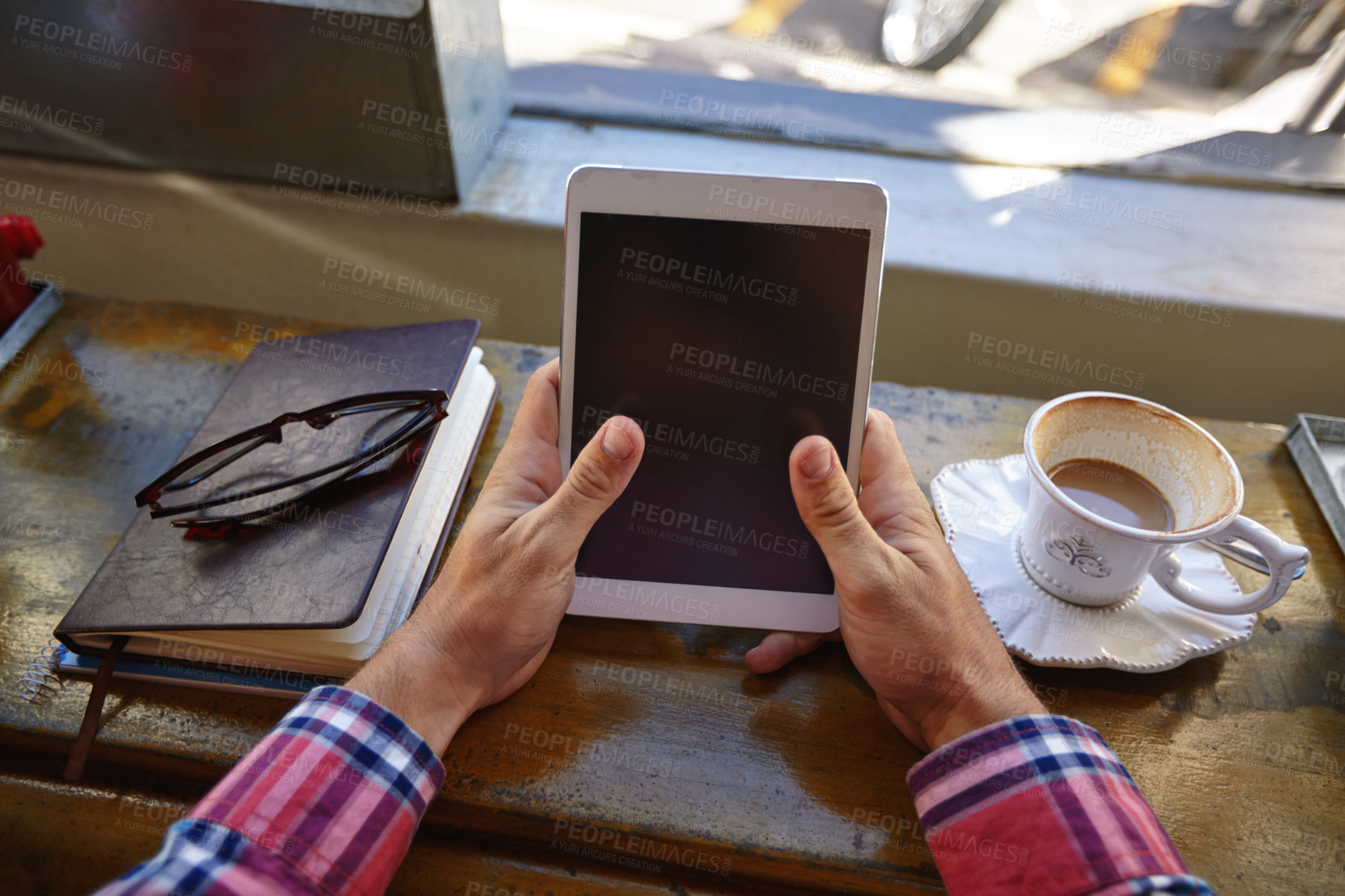 Buy stock photo Cropped shot of a man using a digital tablet at a cafe