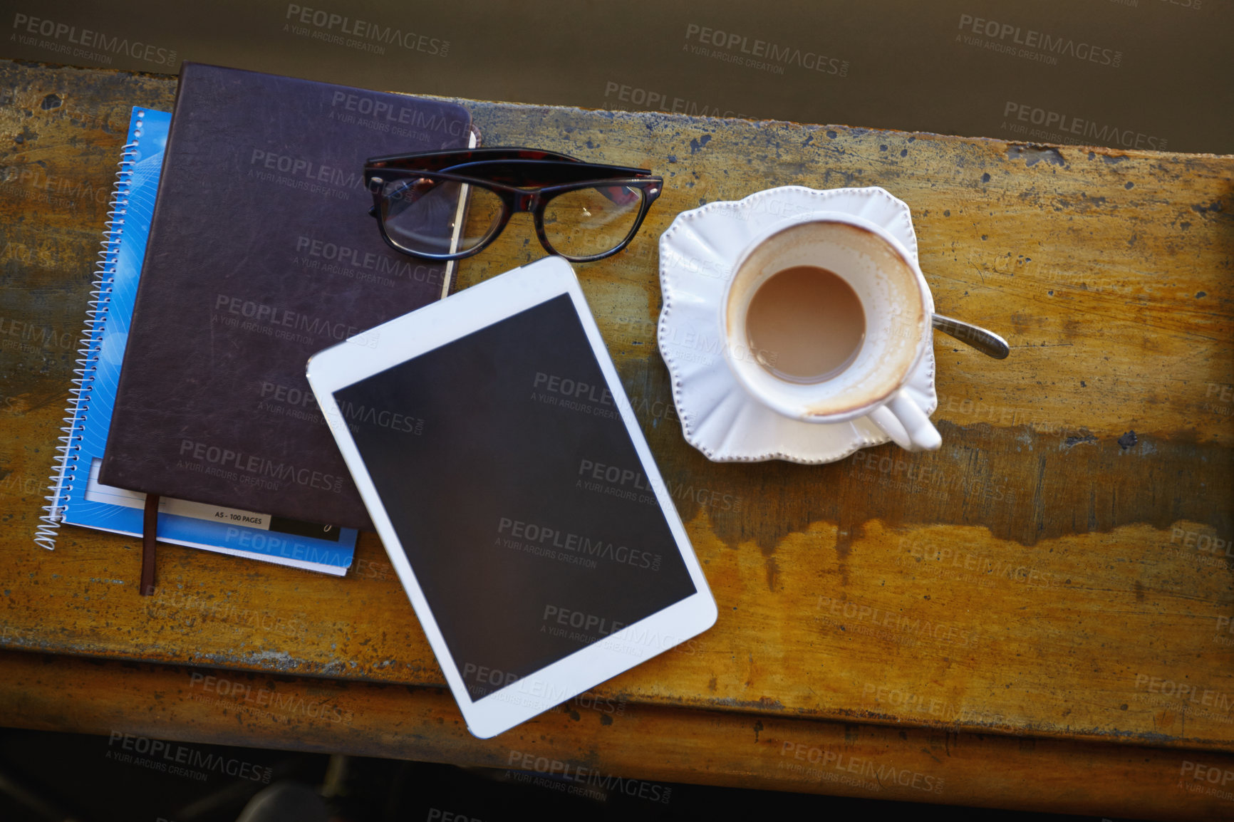 Buy stock photo High angle shot of a tablet, notebooks and coffee cup on a cafe counter