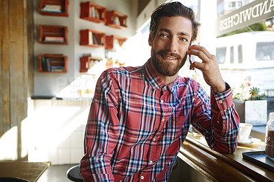 Buy stock photo Shot of a young man sitting in a coffee shop