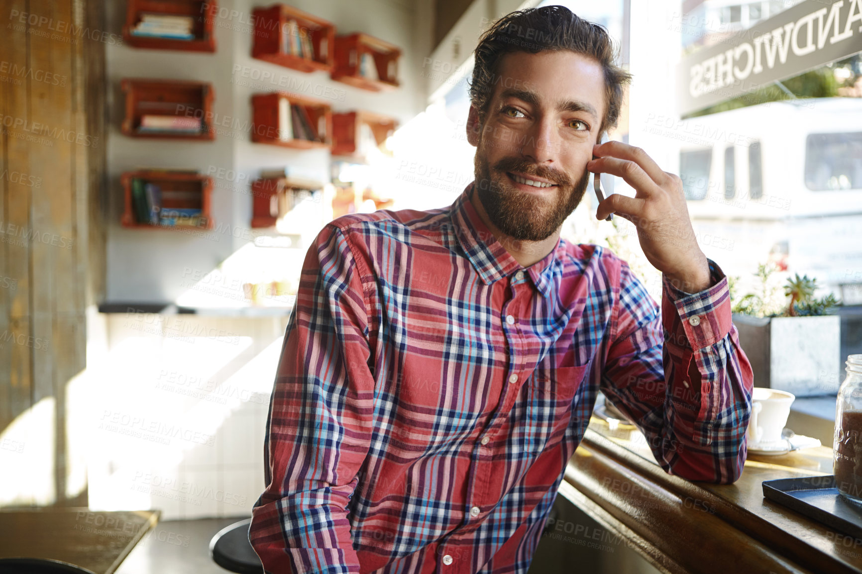 Buy stock photo Shot of a young man sitting in a coffee shop