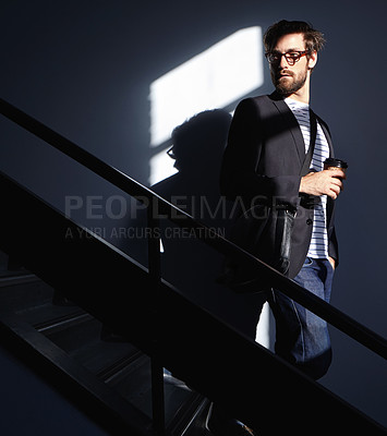 Buy stock photo Shot of a stylish and confident young man walking down a staircase